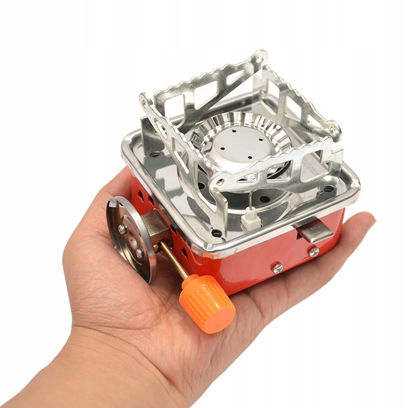 Folded Kovar K-202 stove on a palm, with the canister valve at the side