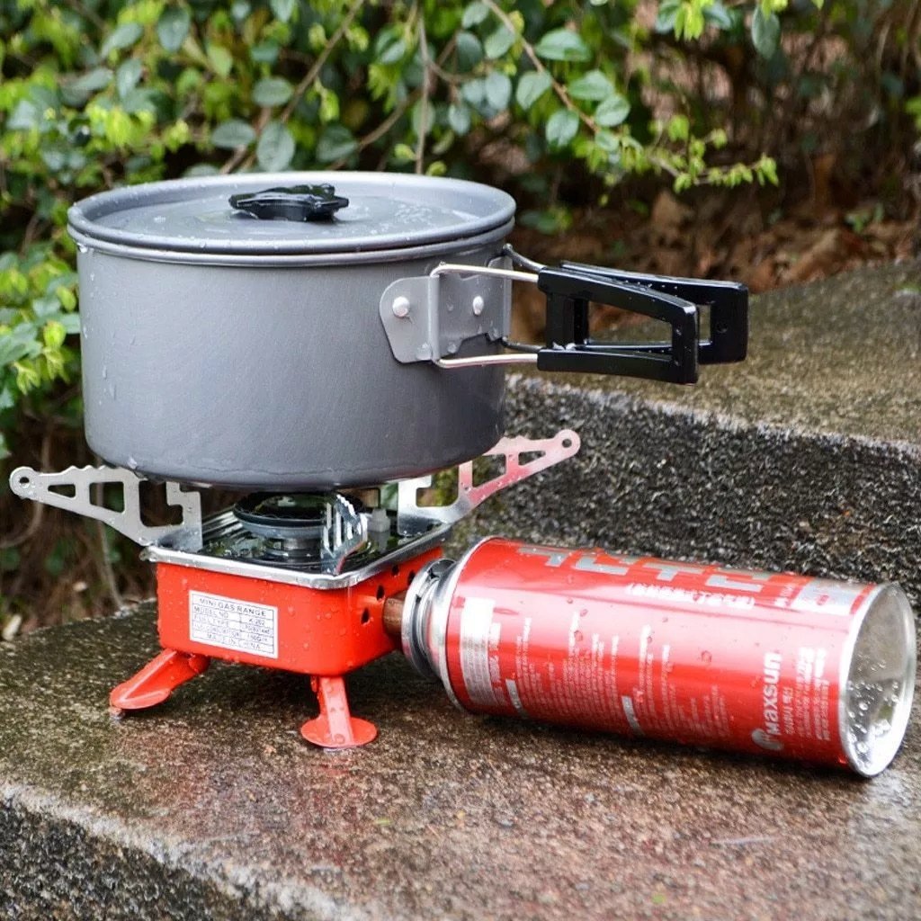 Kovar K-202 stove with a pot on a low wall, connected at the side to a long gas canister